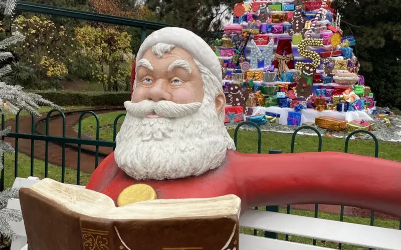 Weihnachtsmann im Europa Park mit Geschenken im Hintergrund
